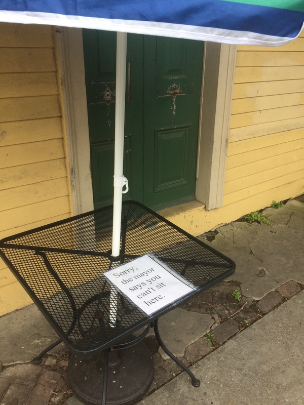 a sign on a metal table saying "sorry the mayor says you can't sit here"