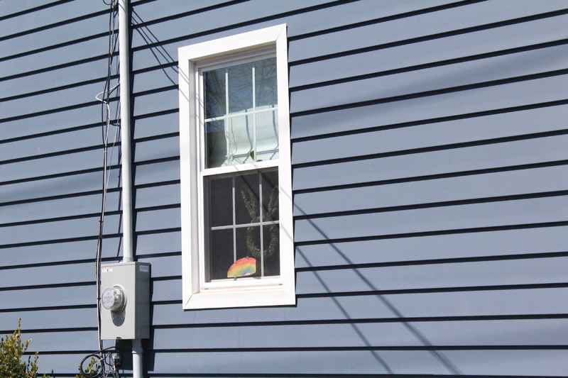 Residential house with a rainbow drawing placed in a window. 