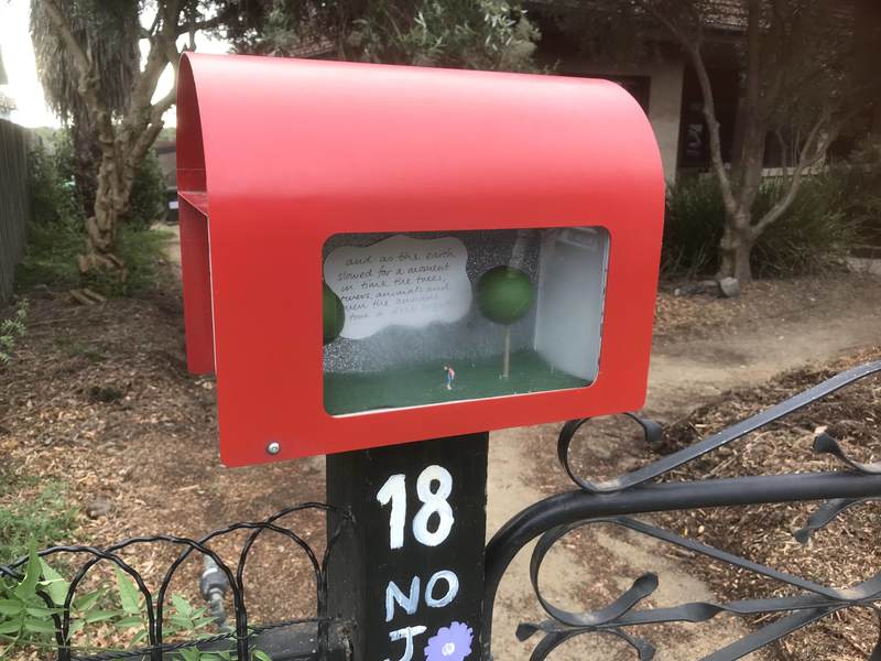 A mailbox with an art display on the side. 