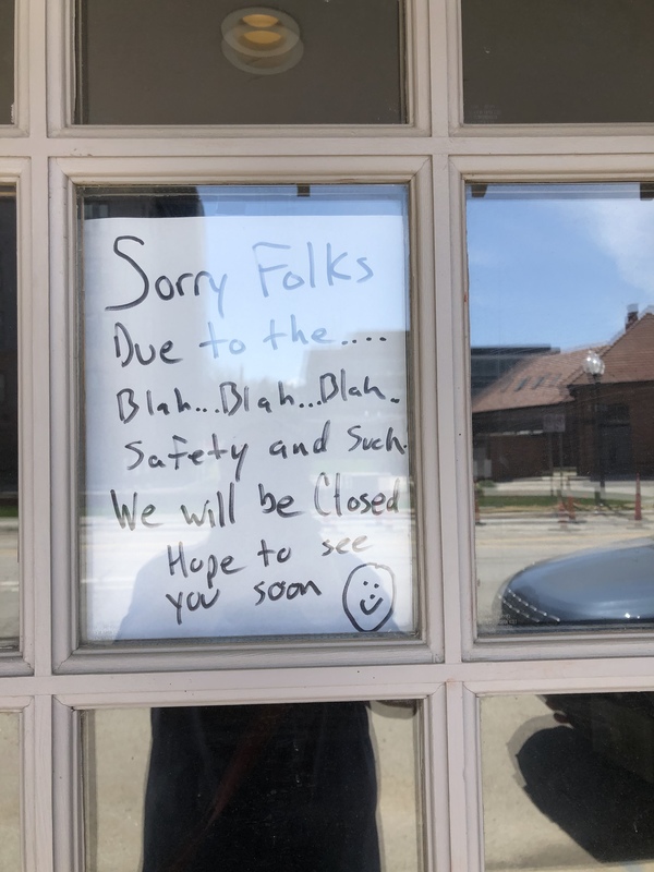 A white sign in the window of a bar. 