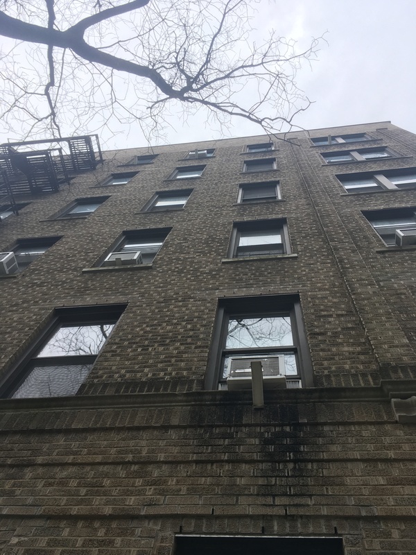 A  view of the side of a brick building facing the sky.