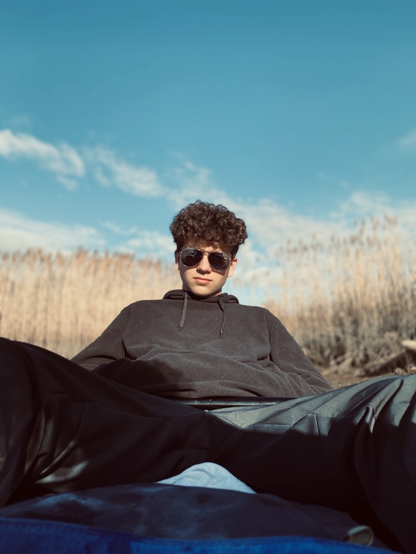 A person sitting down in a field. 