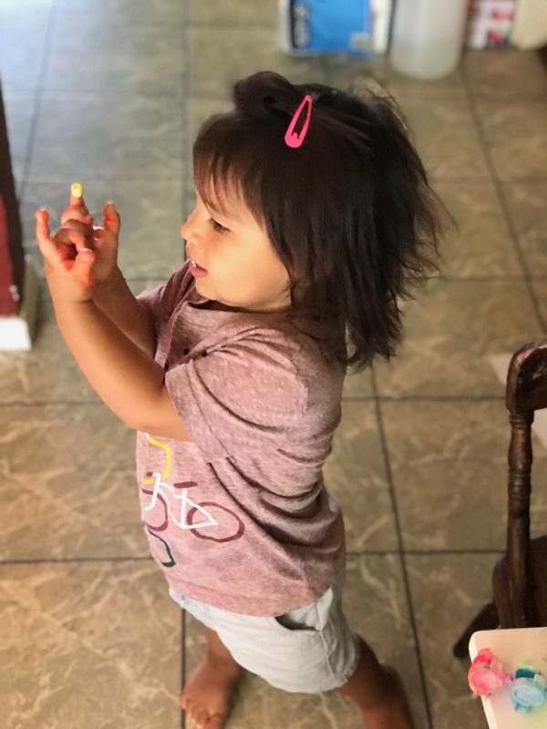 A child with paint on their fingers. 