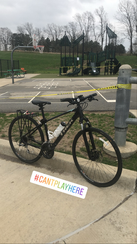 A taped-off playground and basketball court with a bicycle in front of it with  #cantplayhere typed on the photo. 