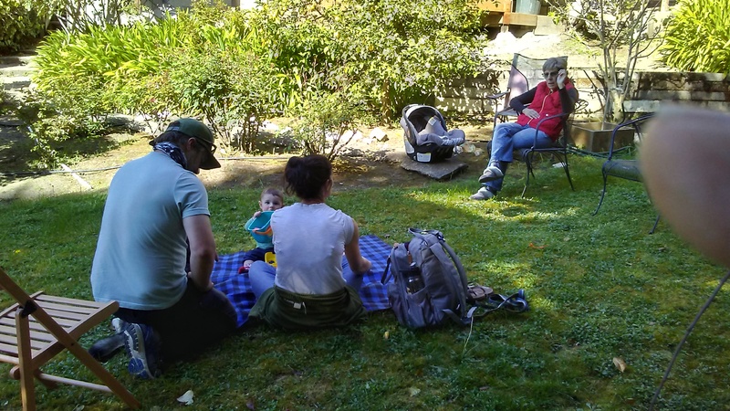 A family interacting but separated by adhering to the need for social distancing while outside. 