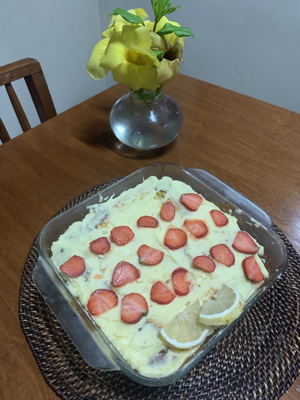 A dish of food and vase of flowers. 