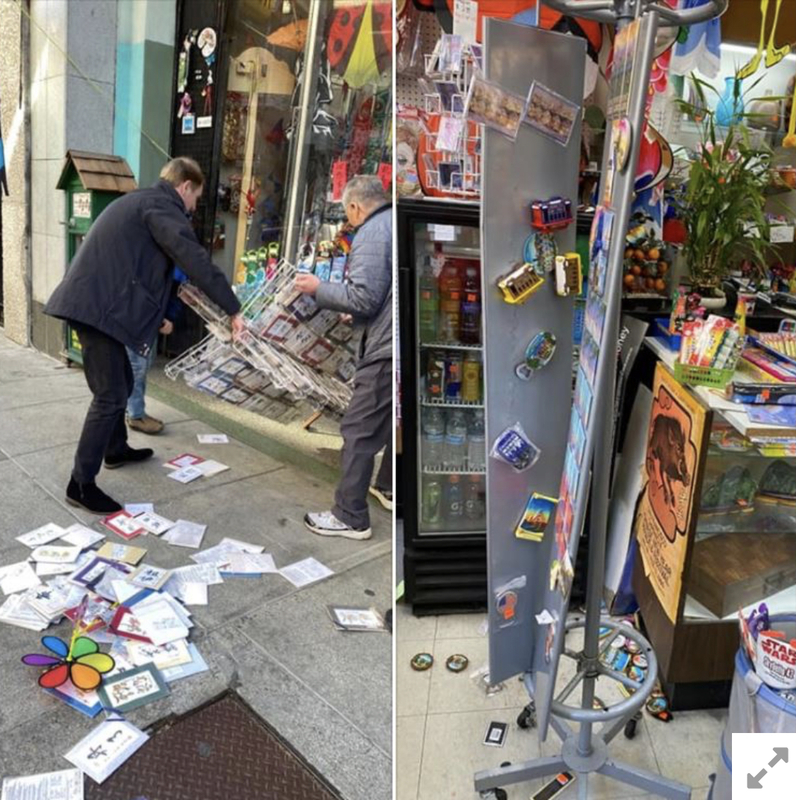 Photo of two men in front of a store fixing a display that was knocked over.