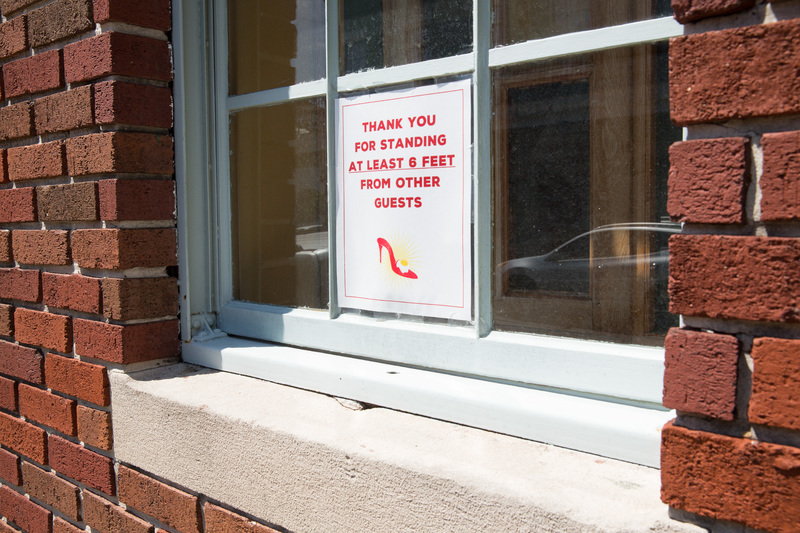 A white sign with red letters in a window.