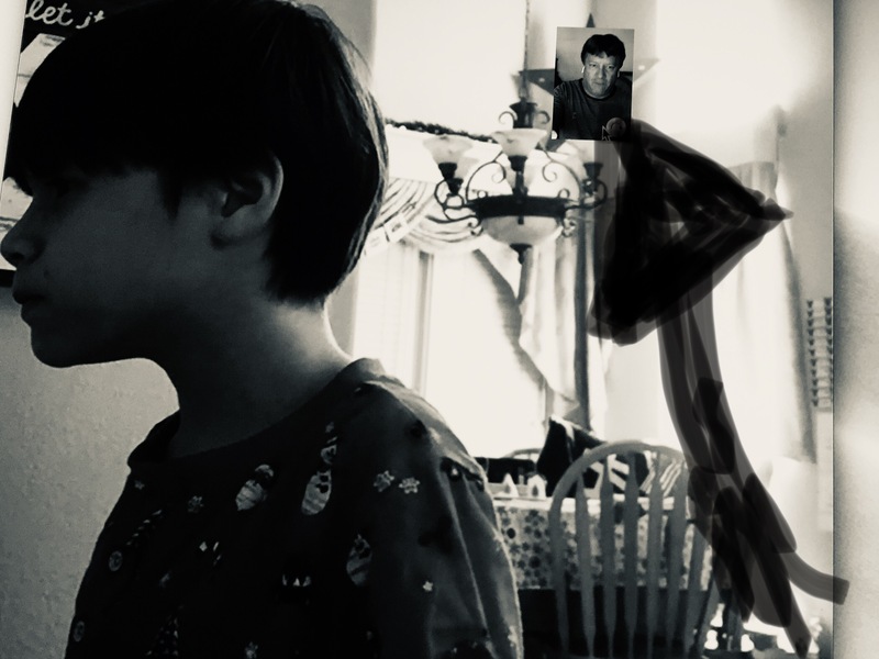 Black and white photo of boy with small photo of piano teacher behind him.