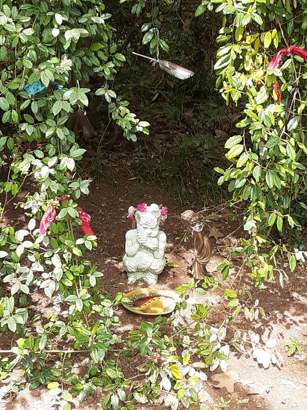 A garden statue surrounded by leaves. 