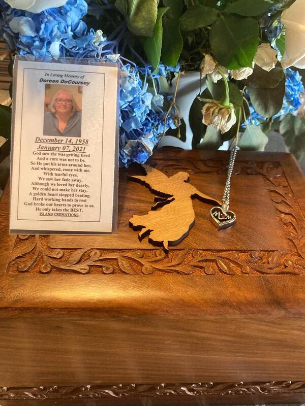 This is a picture of a group of flowers next to a memorial card at what appears to be a funeral or a celebration of life. 