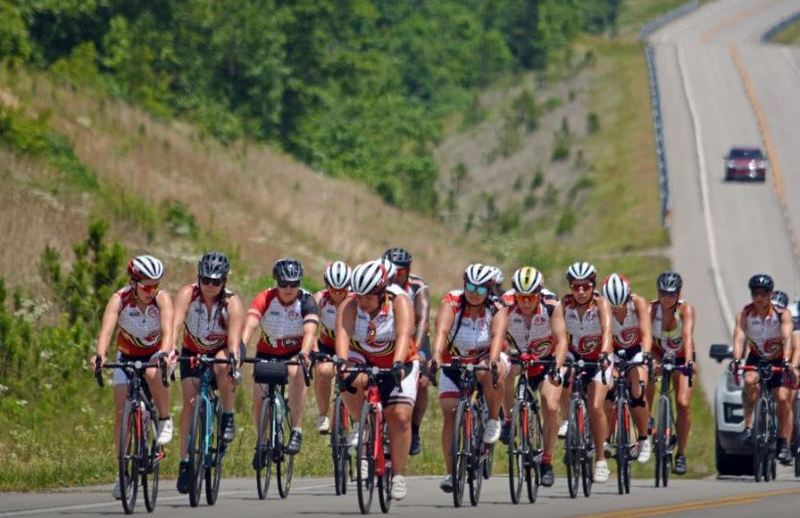 A photo of several people biking on a road.