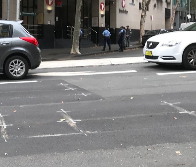 A group of police officers standing outside a hotel.