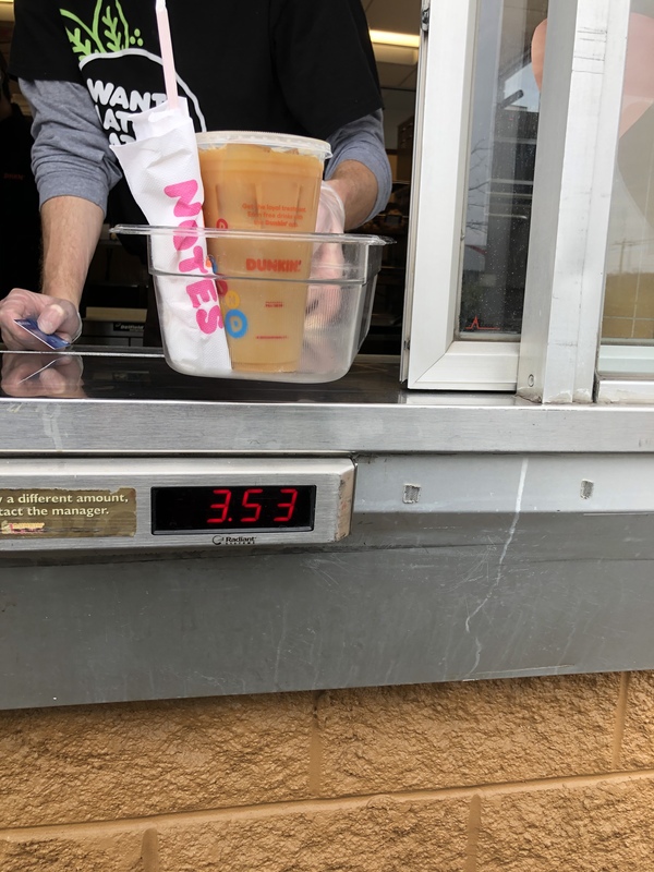 A person holding a container with a bag and drink.