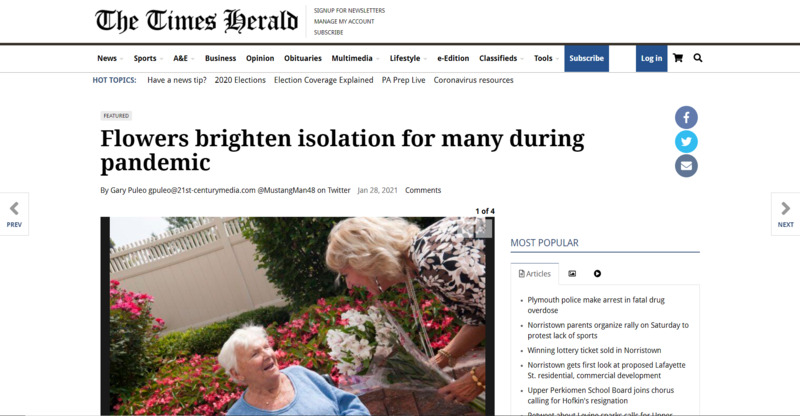 Screenshot of The Times Herald web article.  Image of woman handing flowers to elderly woman.  Headline reads, "Flowers brighten isolation for many during pandemic". 