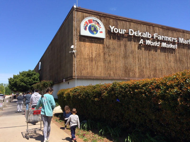 A line of people outside a farmers market. 