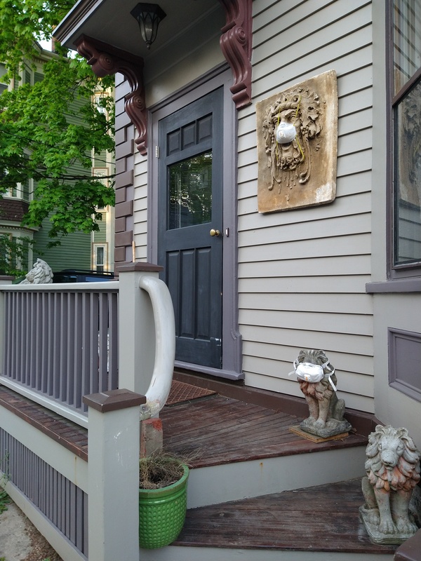 Image of a building off of Chestnut Street with a few lion statues and a Green Man statue in front of it. One lion and the Green Man is wearing a face mask.