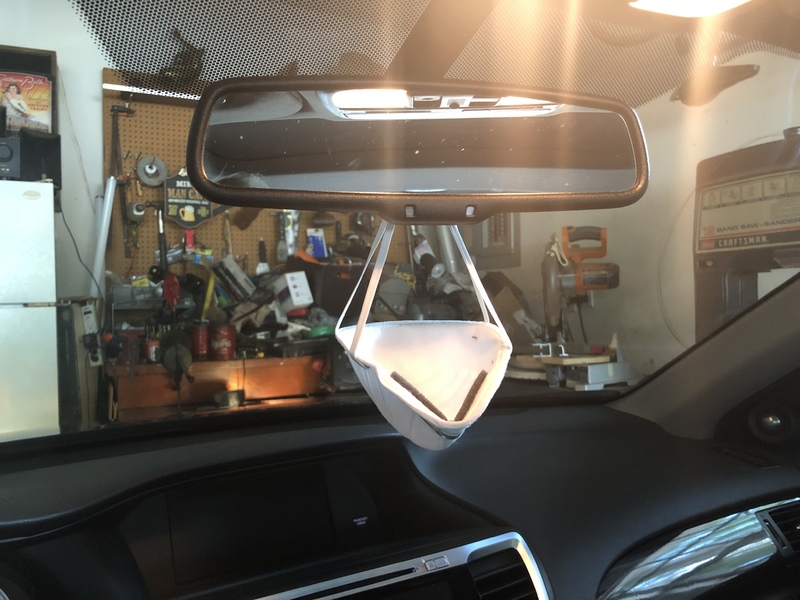 face mask hanging from a car's rear view mirror