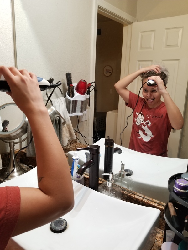 A kid giving themselves a haircut. 