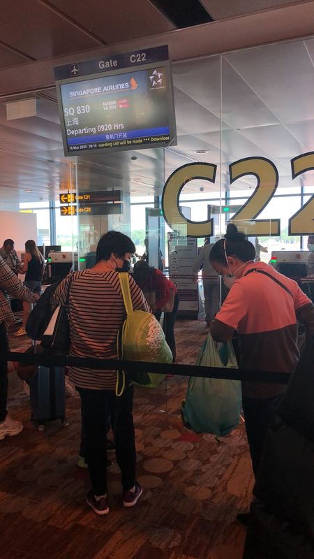 People waiting in line at a boarding gate at an airport. 