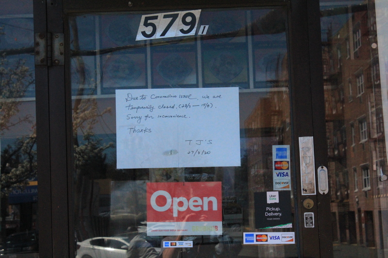 A business with a hand written note on the door that says "Due to Coronavirus issue we are temporarily closed 28/3-15/4. Sorry for any inconvenience. JJ's 27/03/20."