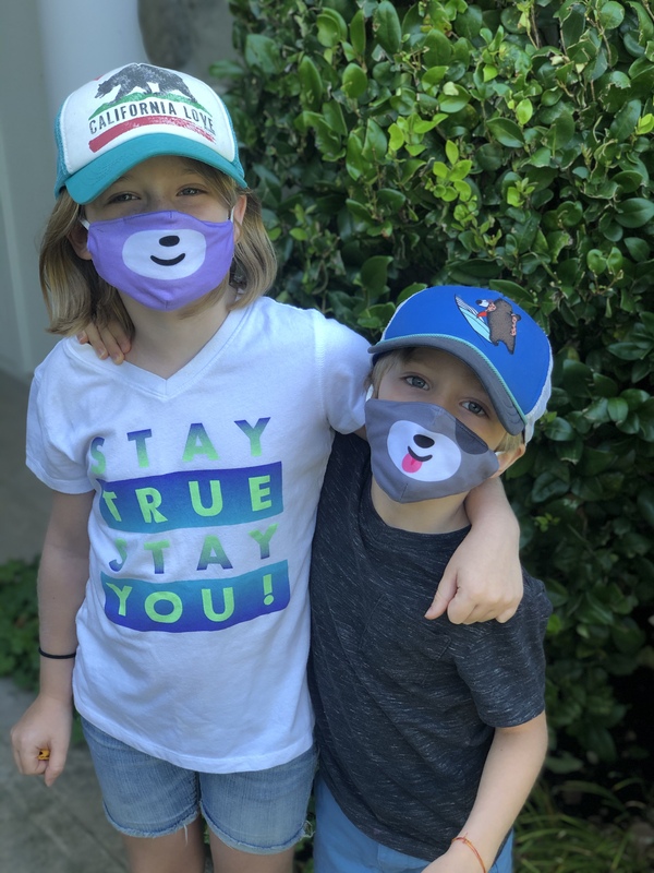 Photo of two children wearing masks. 