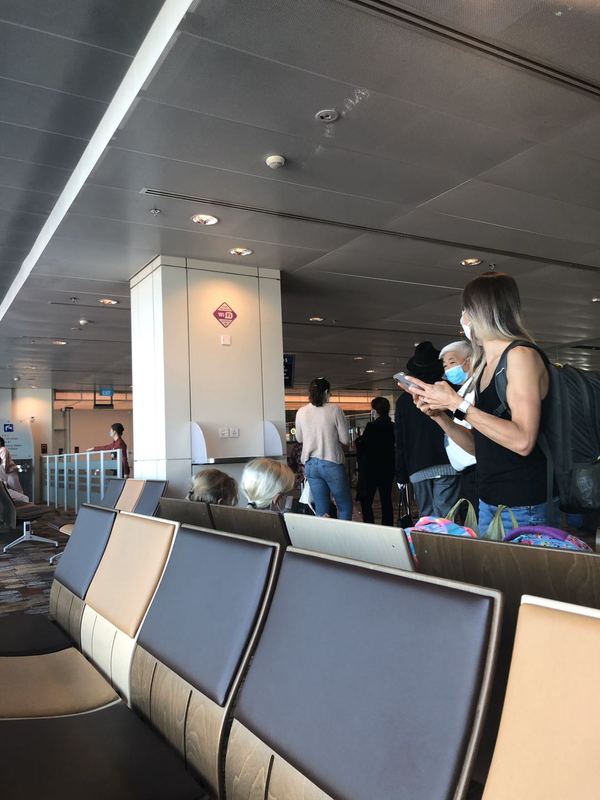 People at the seating/waiting area in an airport concourse. 