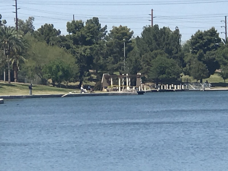 Photograph of people fishing at a lake. 