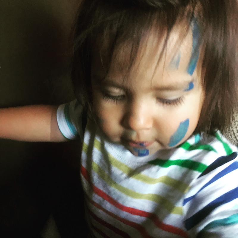 A child with paint on their face. 