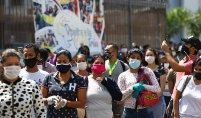 a crowd of people all in face masks and some in gloves