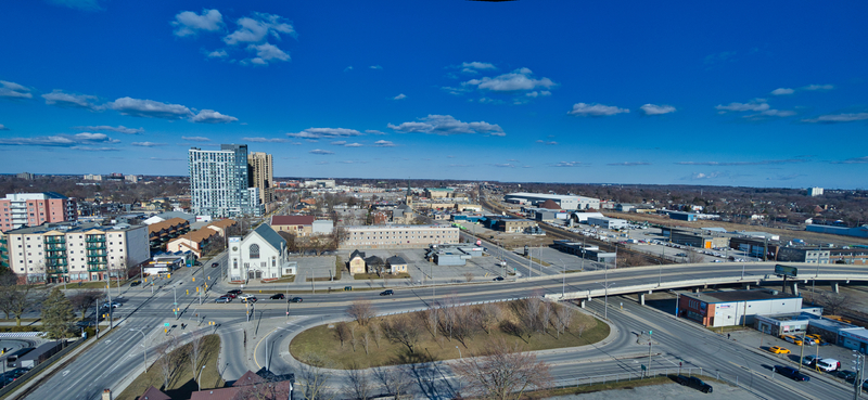 A city with grey building in the distance with not a cloud in the sky. The sun is shining with a bright blue sky. 