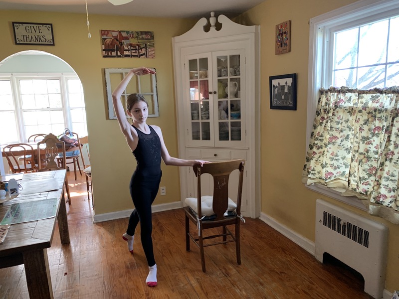 A young dancer practicing by a table. 