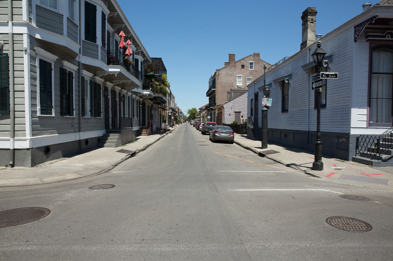 An empty street with cars parked along it.