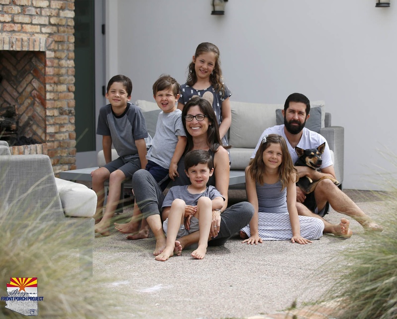 People sitting down, one holding a dog. 