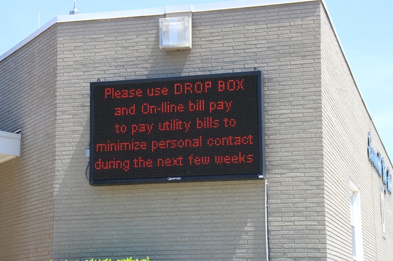 Digital sign reading "Please use Drop Box and on-line bill pay to pay utility bills to minimize personal contact during the next few weeks".