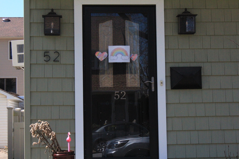 Residential house with a rainbow in the front door and two hearts at each side of it. 