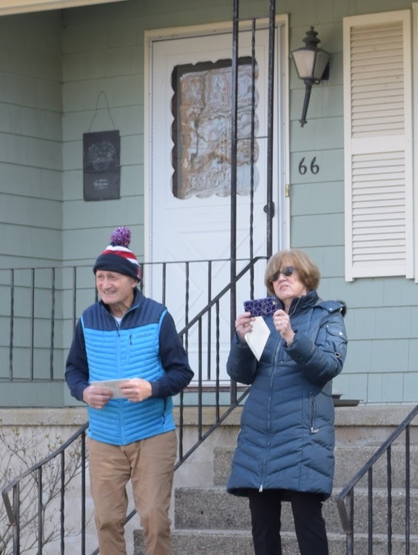 Two elderly people in front of a house. 