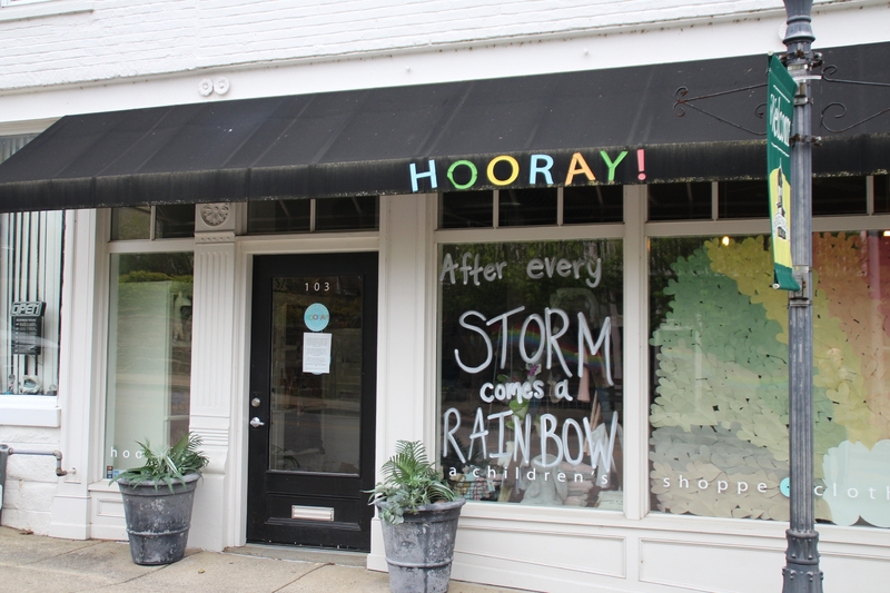 A store window reading "After Every Storm Comes a Rainbow".