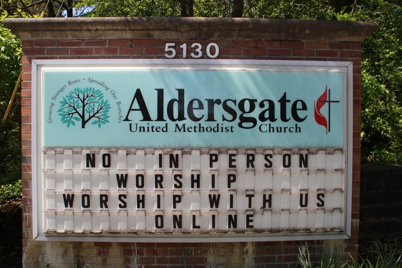 Sign at Aldersgate United Methodist Church reading "No in person worship. Worship with us online".