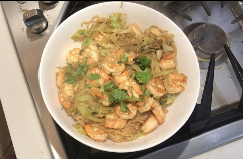 A photo of a plate of food with noodles and shrimp.