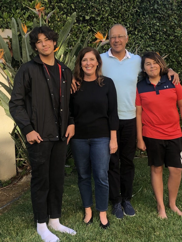 A picture of a family of four outside. 