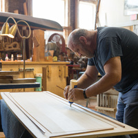 A person applying liquid to a piece of wood.