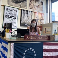 This is a picture taken of a teacher sitting at a desk.