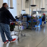 Masked customers and employees at a grocery store. 