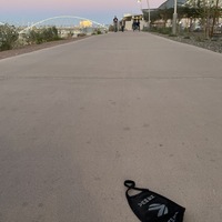 This is a picture of a discarded black cloth face mask left on the sidewalk. 