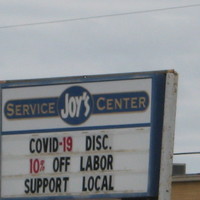 An auto mechanic's sign asking people to shop local