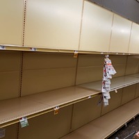 An aisle in a grocery store that has empty shelves. 