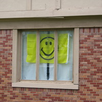 Image of a smiley face flag in a window.