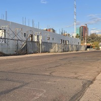 This is a picture of a face mask that has been discarded on the street in front of a construction zone. 