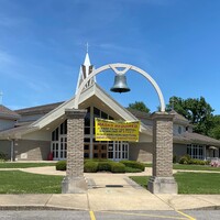 A church exterior with multiple signs. 